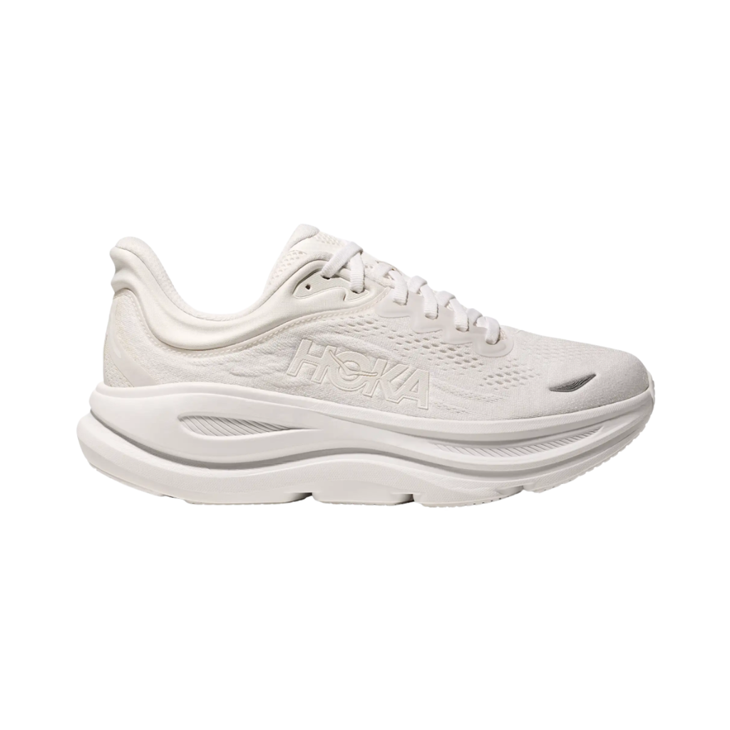 Side view of the HOKA Men’s Bondi 9 in White/White, showcasing the thick super critically foamed EVA midsole, smooth MetaRocker™ profile, and breathable recycled polyester upper for maximum cushioned support.